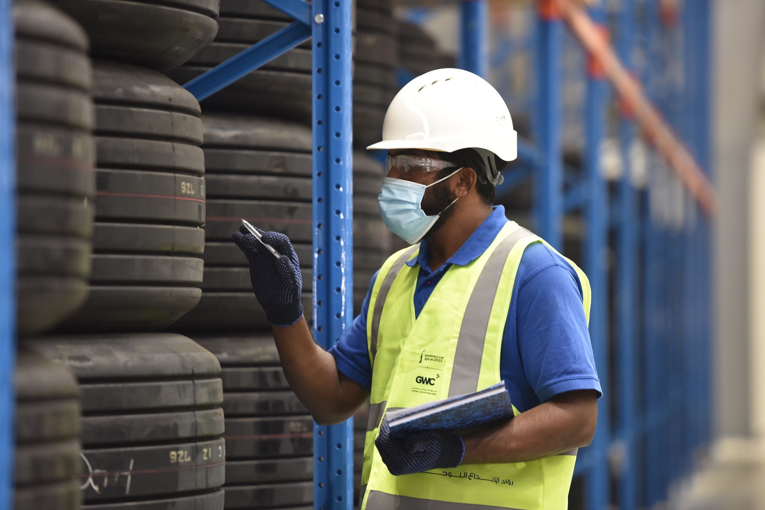 Person inspecting tires in a warehouse