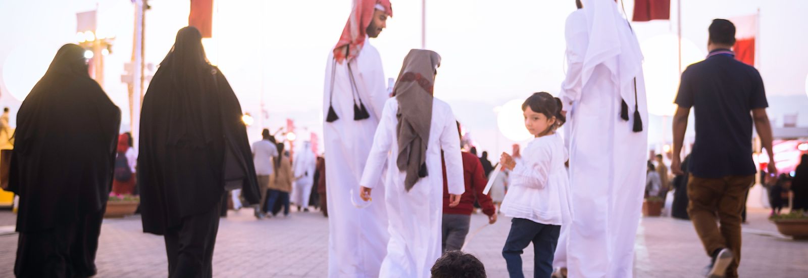 Happy Qatari family, wearing traditional clothing on a walk