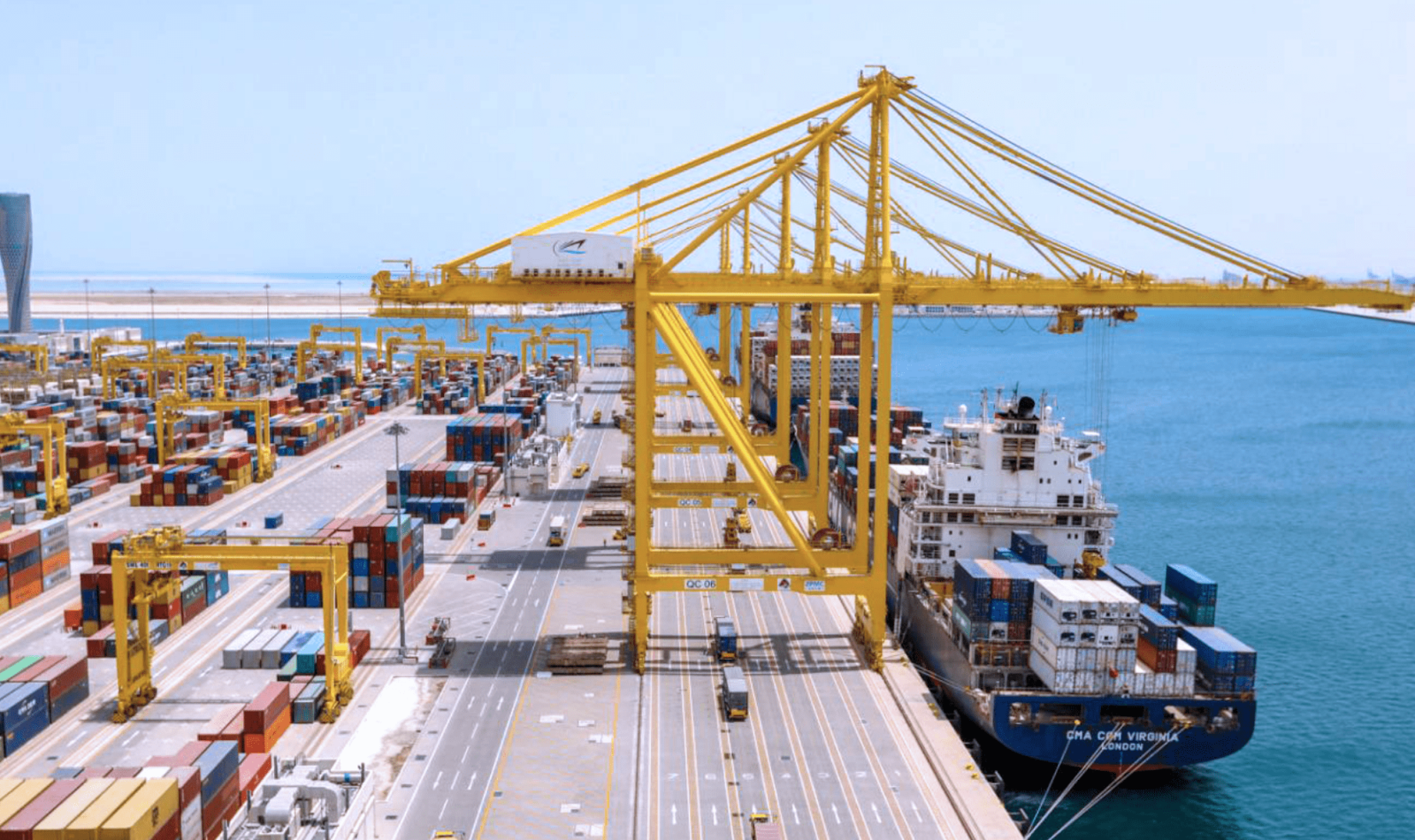 Hamad Port cargo loading, large yellow container cranes placing containers on cargo ships