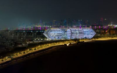 Business Innovation Park at Ras Bufontas Free Zone illuminated along Doha waterfront with city skyline at night