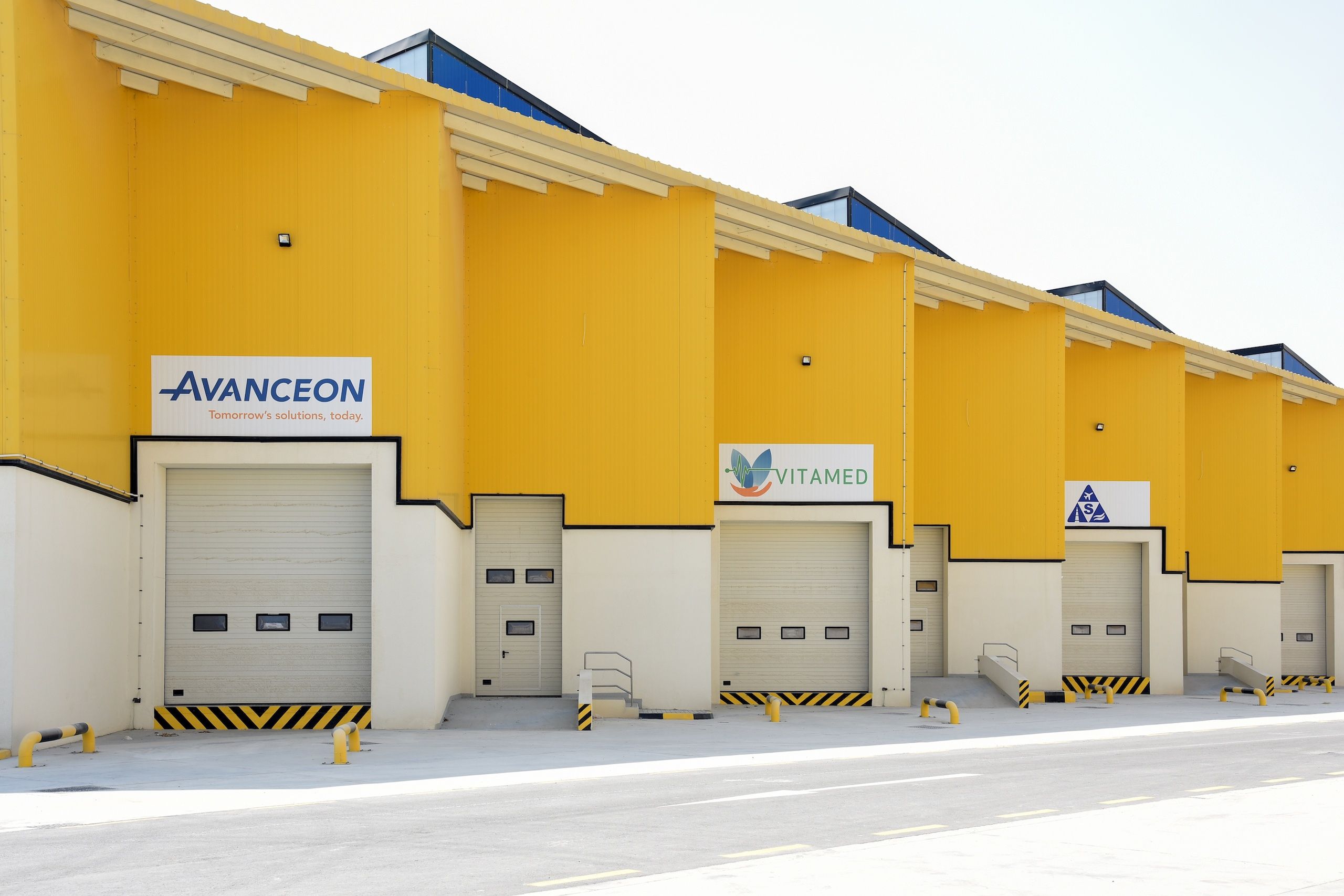 Bright yellow and blue warehousing buildings, with loading docks